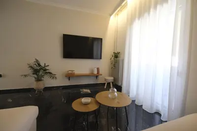 a living room with a couch and a tv at ZEN central flat with seaview by 8essentially in Chania Town