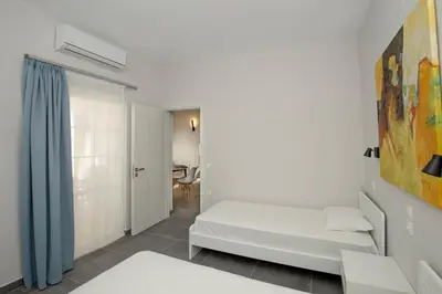 a white room with a bed and a window at El Greco Studios in Agia Marina Nea Kydonias