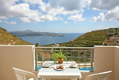 a table on a balcony with a view of the ocean at Aptera Paradise With Sea View in Megála Khoráfia