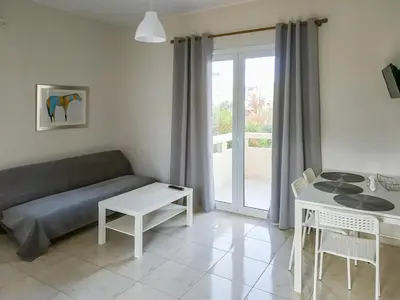 a living room with a couch and a table at Pasithea apts in Almirida