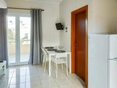 a kitchen with a table and chairs and a refrigerator at Pasithea apts in Almirida