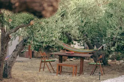 a hammock and a table and chairs under a tree at Amygdalia Traditional House in Chania Town
