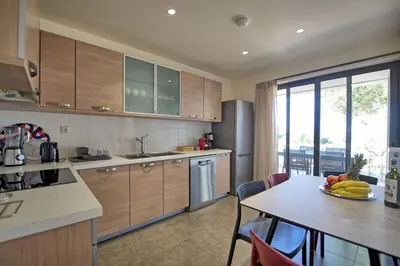 a kitchen with a table with a plate of fruit on it at Iris by PosarelliVillas in Kounoupidhianá