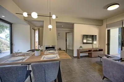 a dining room with a table and chairs at Dioni by PosarelliVillas in Kounoupidhianá