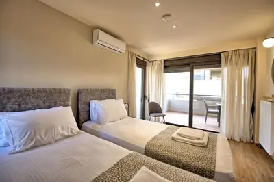 a hotel room with two beds and a balcony at Dioni by PosarelliVillas in Kounoupidhianá