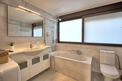 a bathroom with a tub and a sink and a toilet at Dioni by PosarelliVillas in Kounoupidhianá
