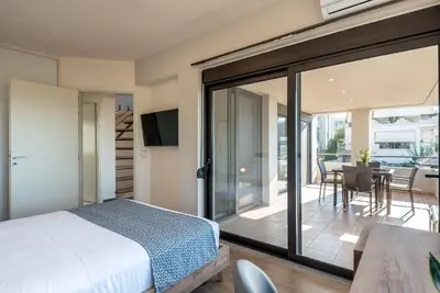a bedroom with a bed and a sliding glass door at Dioni by PosarelliVillas in Kounoupidhianá