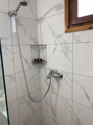 a shower with a hose in a bathroom at Charming house 8 minutes walk from Almyrida beach in Almirida