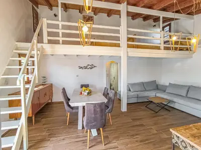 a living room with a loft bed and a table and chairs at Charming house 8 minutes walk from Almyrida beach in Almirida