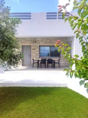 a patio with a table and chairs in front of a building at Gramvousa's Hidden Gem in Áyios Yeóryios