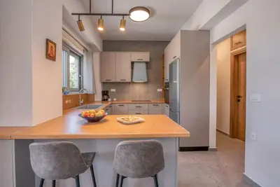a kitchen with a island with two bar stools at Gramvousa's Hidden Gem in Áyios Yeóryios