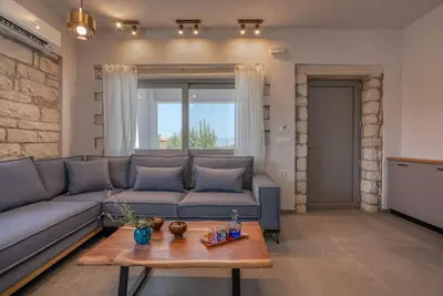 a living room with a couch and a table at Gramvousa's Hidden Gem in Áyios Yeóryios