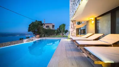 a swimming pool with lounge chairs next to a building at Villa Majestic Crete heated pool and sauna in Megála Khoráfia