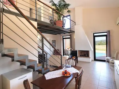 a dining room with a table and a staircase at VILLA ROTUNDA B in Chania Town