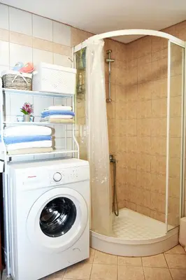 a washing machine in a bathroom with a shower at ESTIA stone house in Vrísai