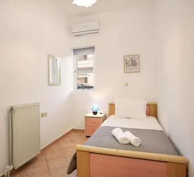 a small bedroom with a bed and a window at Sylvias Stylish Apartment in Chania Town