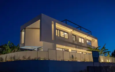 a house with its lights on at night at Luxury Villa Glass - 200 meters From The Beach no6 in Daratso