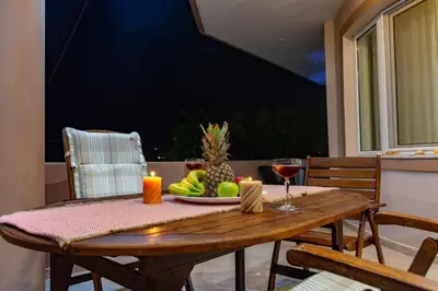 a wooden table with a plate of fruit and a candle at Casa Anthea 3 bedroom apartment with Garden in Kounoupidhianá