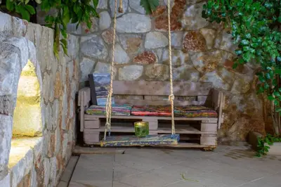 a swing with a candle sitting on a stack of books at Casa Anthea 3 bedroom apartment with Garden in Kounoupidhianá