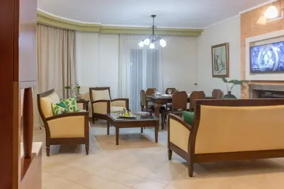 a living room with chairs and a dining room at Casa Anthea 3 bedroom apartment with Garden in Kounoupidhianá