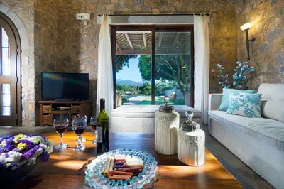 a living room with a couch and a table with wine glasses at Villa Litsarda in Litsárdha
