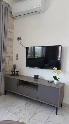 a living room with a large flat screen tv on a wall at Ioanna Apartment 2 in Chania Town