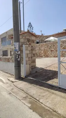 an empty street with a brick wall and a door at Ioanna Apartment 2 in Chania Town