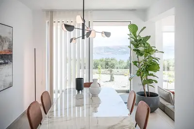 a dining room with a glass table and a plant at Sunny Vacay Villa in Stérnai