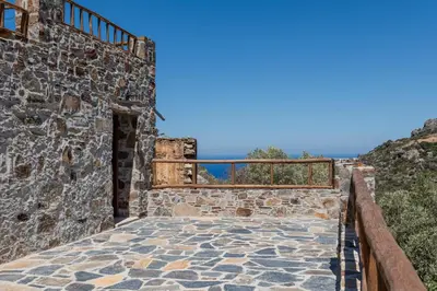 a stairway leading up to a stone building with a balcony at Plagia Rooms in Kissamos