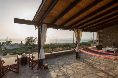 a patio with a hammock and a view of the ocean at Blue Pearl Villa in AmigdhalokeFálion