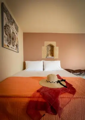 a bedroom with a bed with a hat on it at Blue Pearl Villa in AmigdhalokeFálion