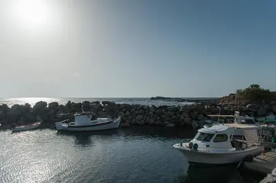 three boats are docked at a dock in the water at Blue Pearl Villa in AmigdhalokeFálion