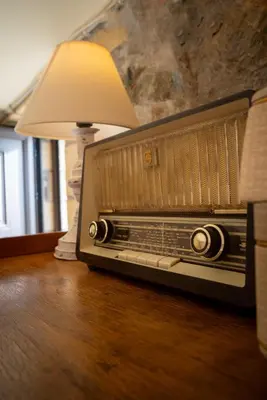 an old radio sitting on a table with a lamp at Blue Pearl Villa in AmigdhalokeFálion