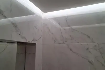 a bathroom with marble walls and a white ceiling at Luxury apartment in the heart of the city in Chania Town