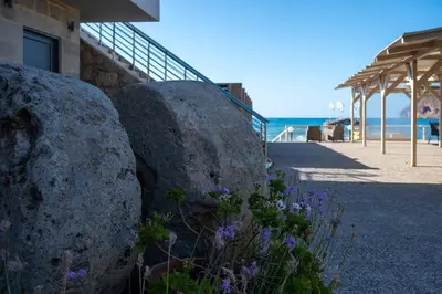 a couple of large rocks next to a beach at Celeste Junior Suite on the Beach in Agia Marina Nea Kydonias