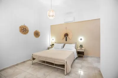 a bedroom with a bed and two mirrors on the wall at Celeste Junior Suite on the Beach in Agia Marina Nea Kydonias
