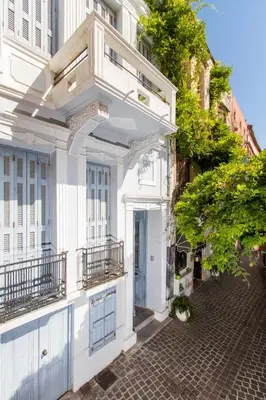 a white building with a balcony on a street at Casa Ari - Venetian Port in Chania Town
