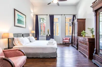a bedroom with a bed and a couch and a chair at Casa Ari - Venetian Port in Chania Town