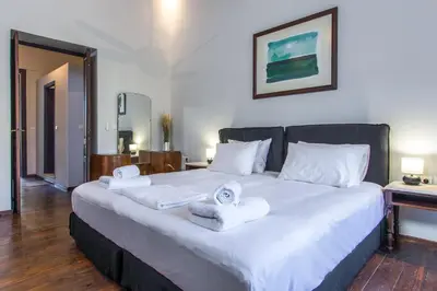 a bedroom with a large white bed with towels on it at Casa Ari - Venetian Port in Chania Town