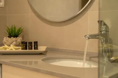 a bathroom sink with a faucet and a mirror at Koutris Apartment 2 in Falasarna