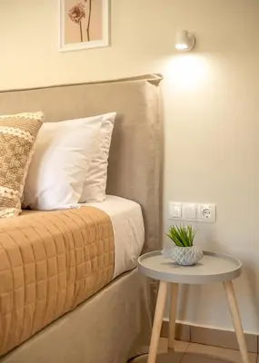 a bedroom with a bed with a table next to it at Koutris Apartment 2 in Falasarna