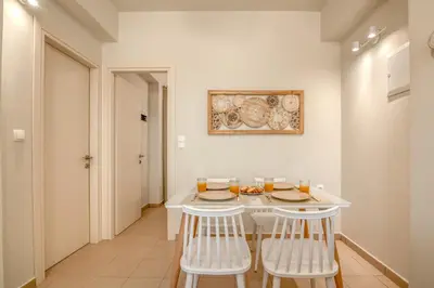 a dining room with a white table and chairs at Koutris Apartment 2 in Falasarna