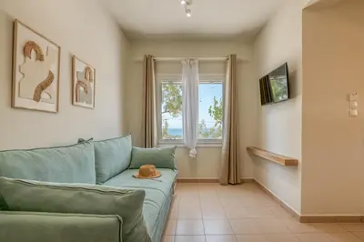a living room with a green couch and a window at Koutris Apartment 2 in Falasarna
