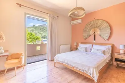 a bedroom with a bed and a large window at The Leaf House in Varípetron