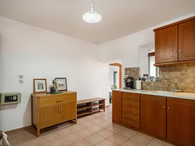 a kitchen with wooden cabinets and a counter top at The Hillside Home in Plataniás