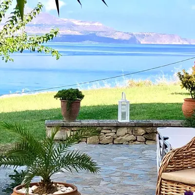 a view of the ocean from a patio with a plant at Cloudberry in Kalyves
