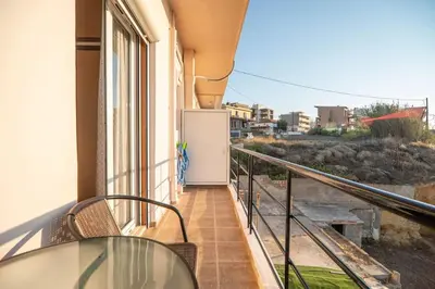 a balcony with a table and chairs on a building at Sea Gem family in Chania Town
