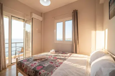 a bedroom with a bed with a view of the ocean at Sea Gem family in Chania Town
