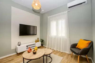 a living room with a tv and a chair and a table at Callisto House in Kalyves in Kalyves