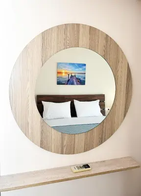 a circular mirror above a bed in a room at eleftheria's apartment in Chania Town